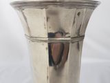 a silver vase sitting on a table with a white background