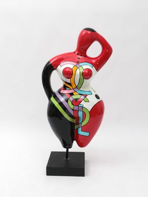ceramic figurine of a woman holding a red vase on a black base