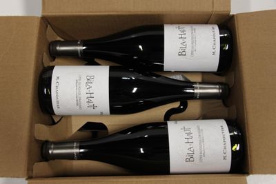three bottles of wine in a cardboard box on a table