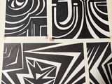 Quatre découpages artistiques différents, en noir et blanc, sont posés sur une table