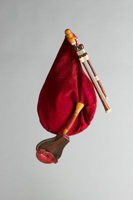 un sac rouge auquel est accroché un instrument de musique sur le côté