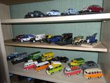 de nombreuses petites voitures et camions sur une étagère dans une pièce
