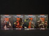 Quatre livres de la série « Kill Team » sont alignés sur une surface noire