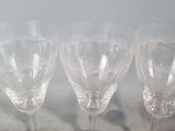 four wine glasses sitting on a tray on the counter