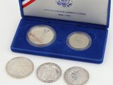trois pièces d'argent dans un étui bleu orné d'un drapeau américain sur le dessus