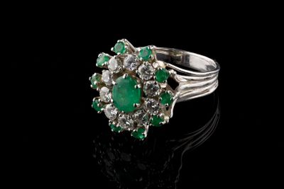 une bague à pierres serties d'émeraudes et de diamants sur un fond noir