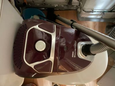 un aspirateur posé par terre à côté d'un bidon