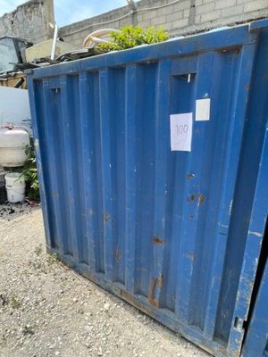 une benne bleue garée devant un immeuble