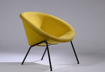 une chaise jaune posée sur un piètement en métal noir