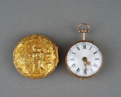 a gold pocket watch and a gold coin on a table