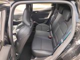 the back seats of a car with the door open and the driver ' s seat down
