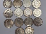 a group of silver coins on a white surface