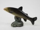 figurine of a fish on a rock on a white background