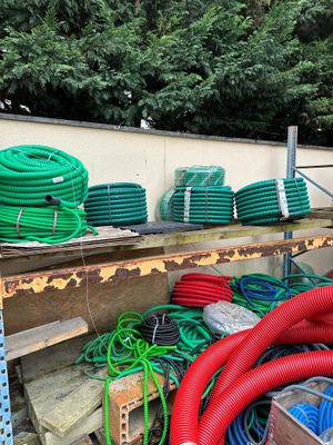 many different colored hoses on a shelf next to a wall