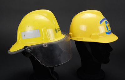 deux casques de chantier jaunes surmontés d'une visière de protection