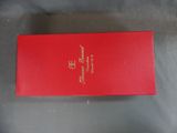 an open red box with gold writing on it sitting on a gray surface