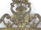 a mirror that has a gold frame with a face on it
