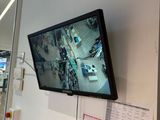 une télévision à écran plat fixée au mur au-dessus d'un extincteur