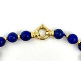 bracelet with blue glass beads and a gold clasp on a white background