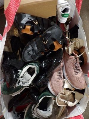 plusieurs paires de chaussures dans un sac posé par terre