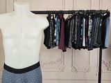 un mannequin masculin devant un présentoir de vêtements