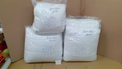 three bags of white pillows sitting on top of a cardboard box