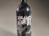 an old bottle of wine sitting on top of a table