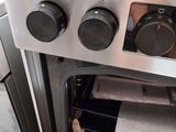a silver oven with three burners and a white towel in it