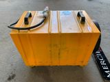a yellow box with a hose attached to it on the ground