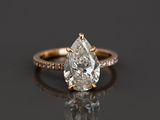 une bague de fiançailles sertie d'un diamant en forme de poire entouré de petits diamants