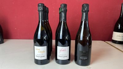 quatre bouteilles de vin sont alignées sur un comptoir