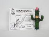 a small figurine of a cactus with a sign in the background