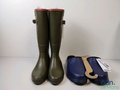 two pairs of green rain boots and a blue case on a white surface