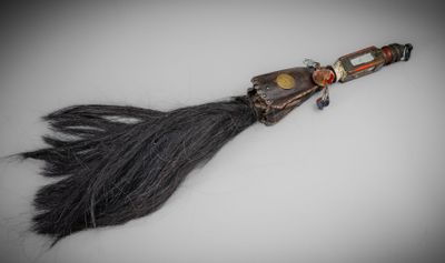 une image représentant une longue brosse à cheveux noire avec un manche en bois