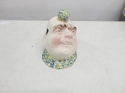 a ceramic figurine of a man with a hat on his head