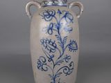 a blue and white vase sitting on a gray surface