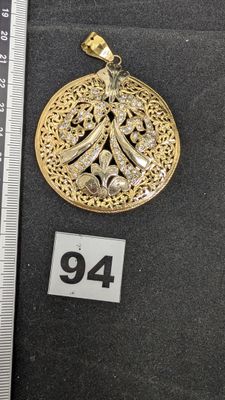 une photo d'un pendentif en or serti de diamants