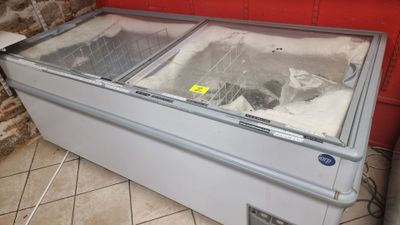 a freezer that is sitting on the floor in front of a red wall