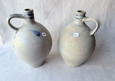 deux vases posés l'un à côté de l'autre sur une surface blanche