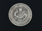une vieille pièce d'argent représentant un dragon sur fond noir