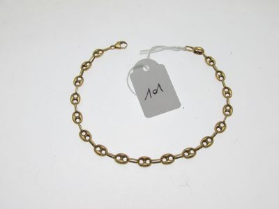 a close up of a gold chain bracelet with a tag on it
