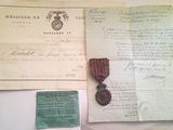 un vieux document orné d'un ruban rouge et d'une médaille, posé sur une table