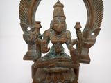 bronze statue of a woman sitting on a throne with two birds