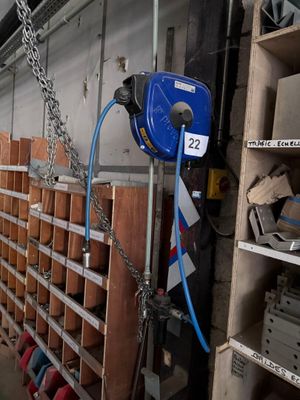 un tuyau bleu fixé au mur d'un entrepôt