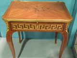 a small wooden table with a gold decoration on it