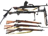 several different types of guns are lined up on a white surface