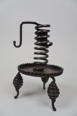 une petite chaise en métal munie d'un ressort hélicoïdal