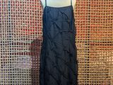 a black dress on a mannequin mannequin stand in front of a wall