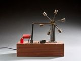 une petite maquette d'éolienne posée sur un socle en bois