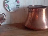 de nombreuses casseroles et poêles en cuivre posées sur une étagère en bois
